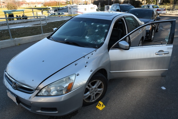 The Complainant's Honda Accord with several bullet holes visible on the front left quarter panel, hood and windshield.