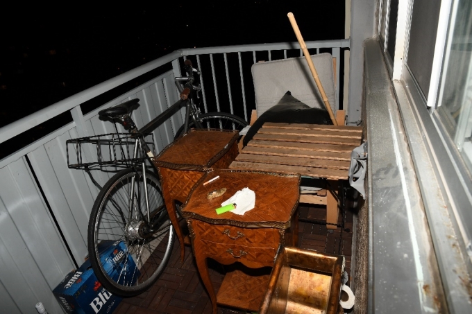 Figure 2 - The balcony of the apartment. Numerous items, including a bicycle and various pieces of furniture, are present.