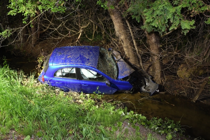 Figure 1 — La Nissan Micra à l’endroit où elle s’est immobilisée, dans un fossé, partiellement immergée et affichant d’importants dommages à l’avant.