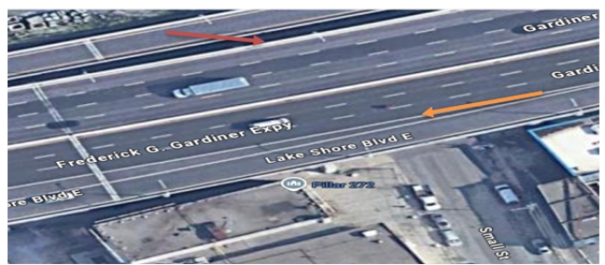Figure 1 — Vue aérienne de l’autoroute Gardiner alors qu’elle passe au dessus de la rue Small. La flèche orange indique l’endroit où la BMW a été contenue et où la poursuite à pied a commencé, et la flèche rouge indique l’endroit où le plaignant a sauté par dessus la glissière de sécurité de l’autoroute.  
